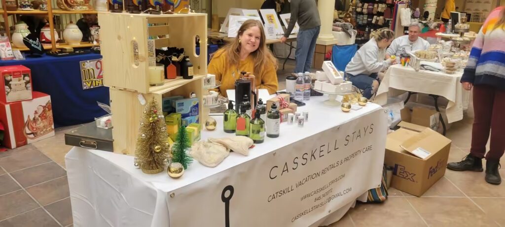 Woman representing Casskell Stays at a holiday market, promoting vacation rentals and eco-friendly products.