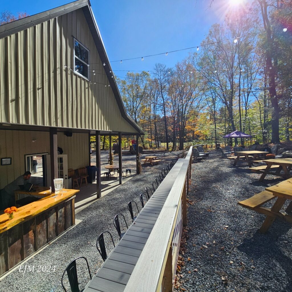 View of the Two Farms Brewery and outdoor seating area with fall foliage in background. 