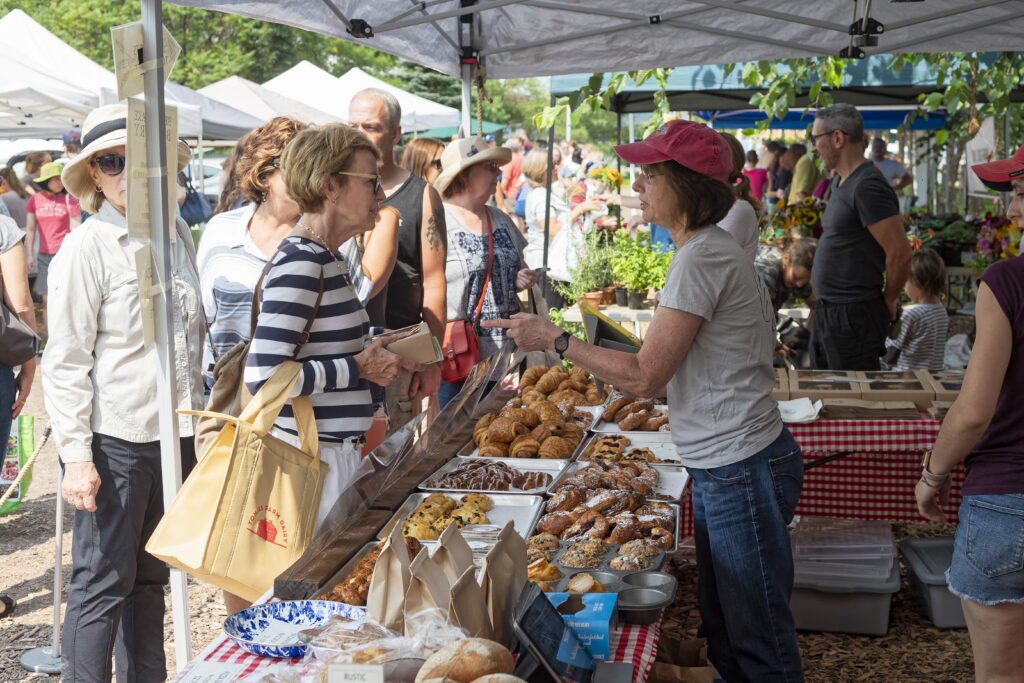 A woman speaks with a vendor at a baked goods booth at the Callicoon Farmers Market.