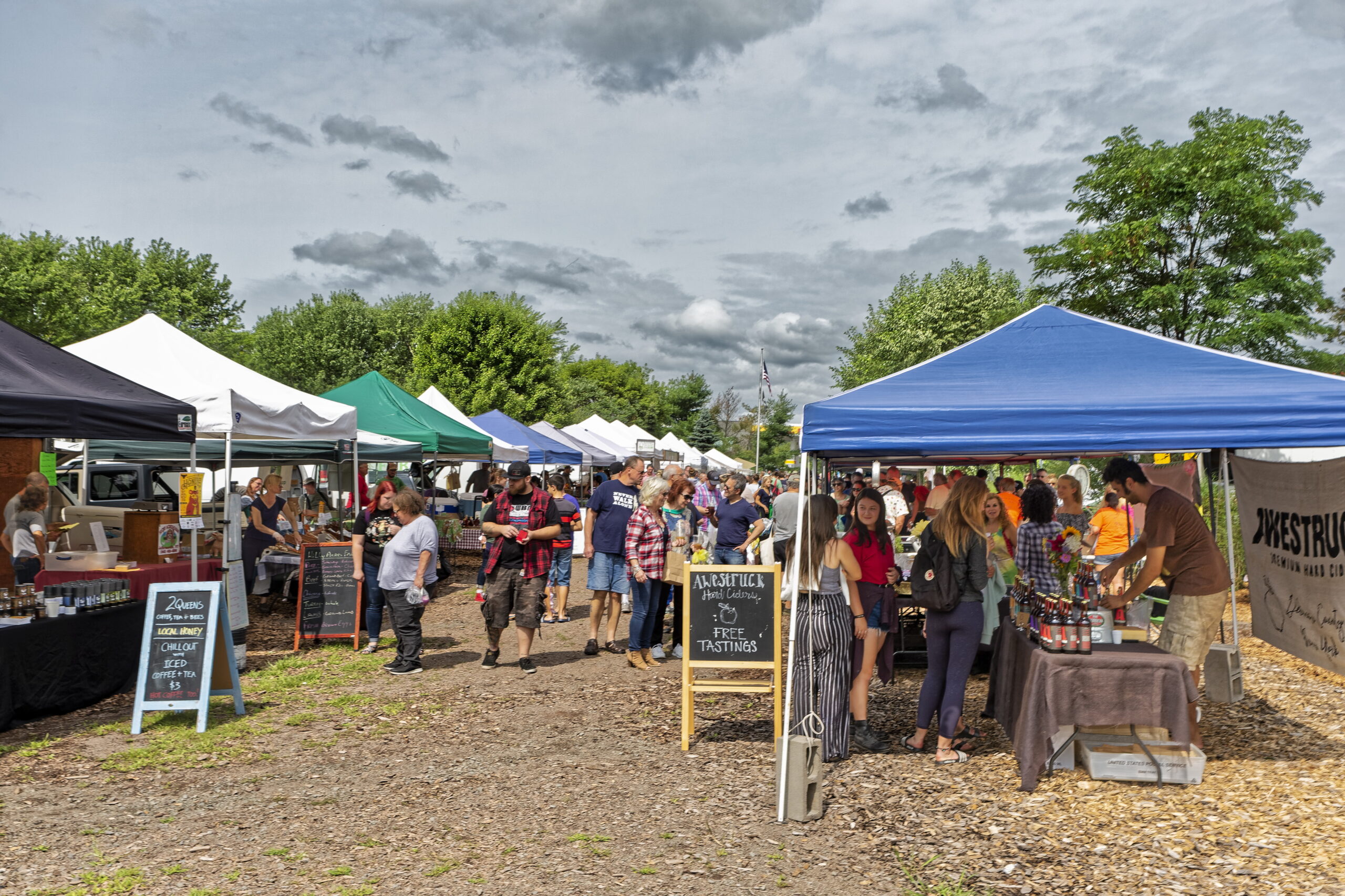 Rows of booths and people milling at the Callicoon farmers market in Sullivan Catskills.