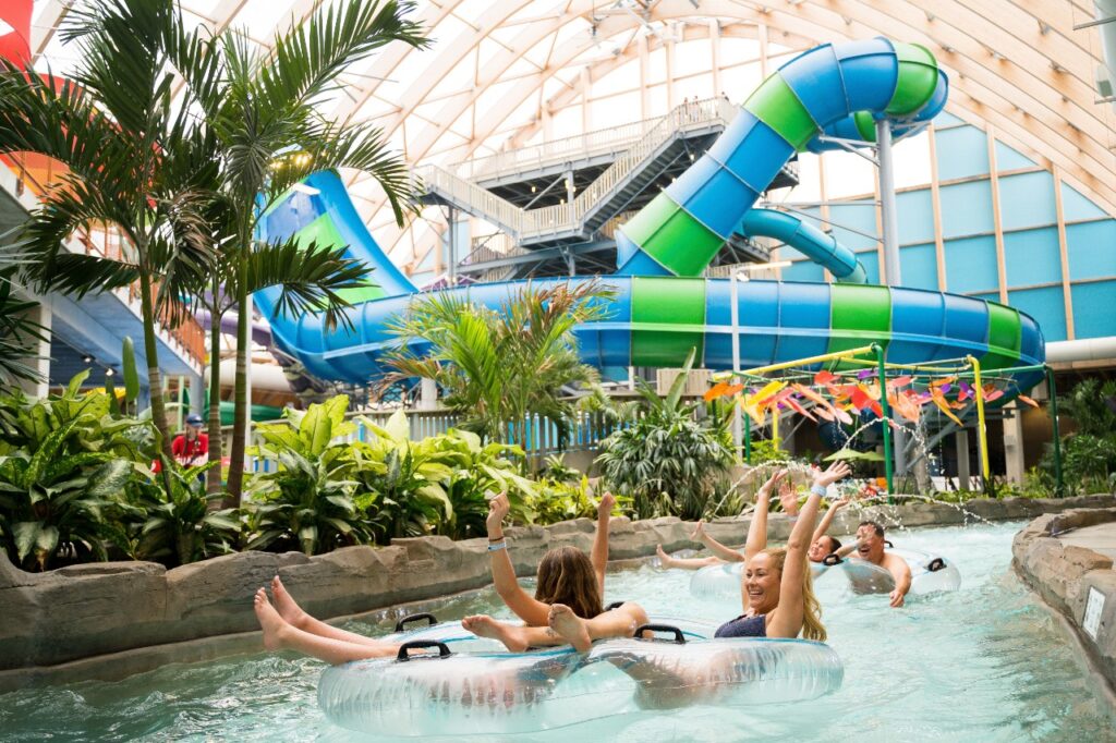 People float down a lazy river with water slides in the background at the Kartrite Resort & Waterpark. 