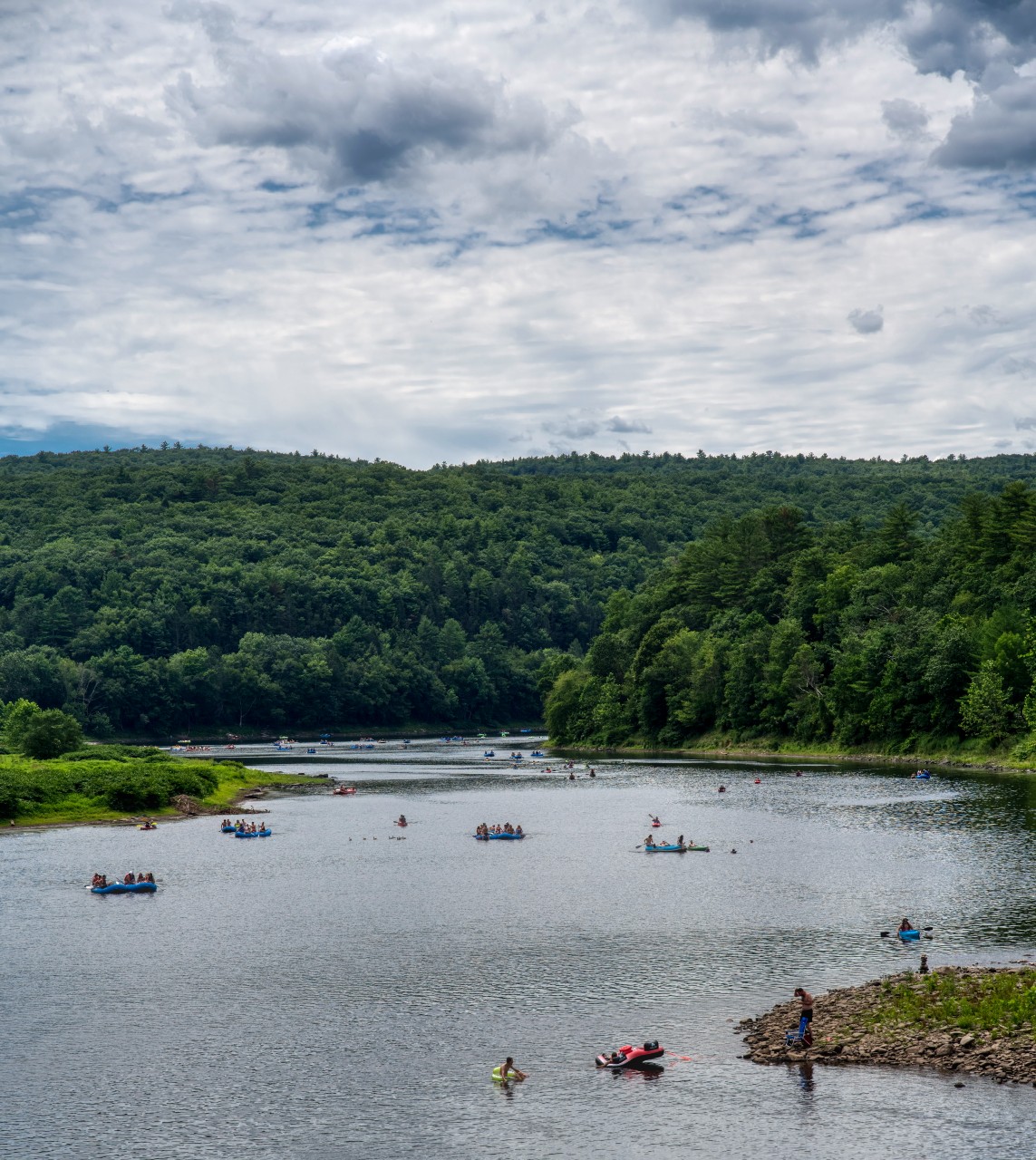 Kayakers and rafters playing on the Delaware River in the Sullivan Catskills.