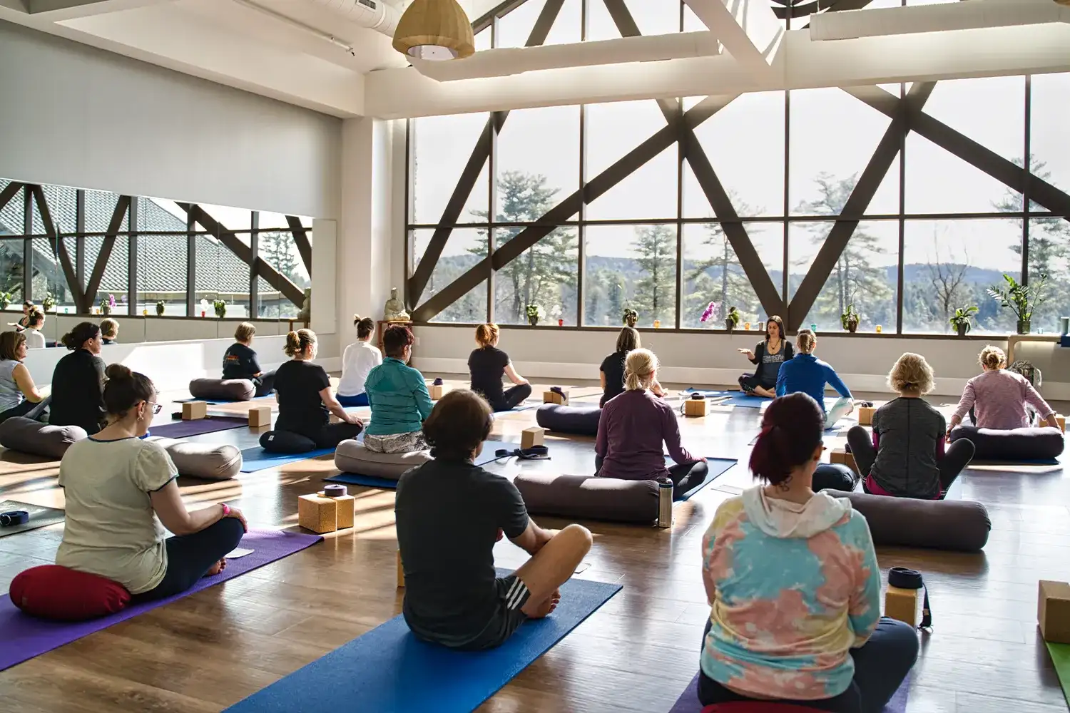Group of yoga participants practicing in meditative indoor setting