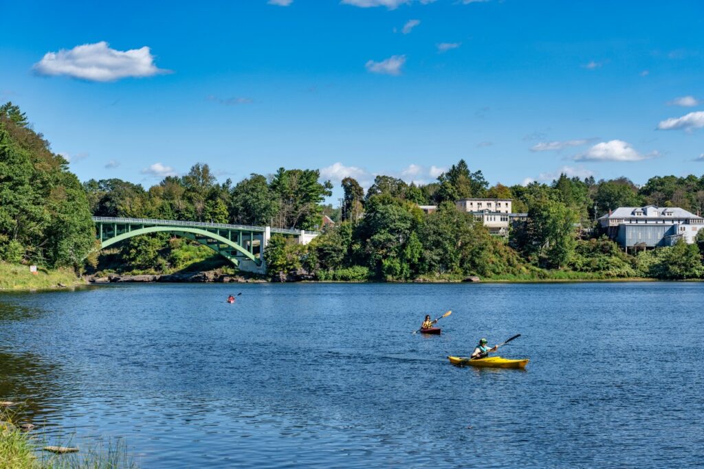 Kayakers paddling with the Narrowsburg Bridge in the background in Sullivan County.