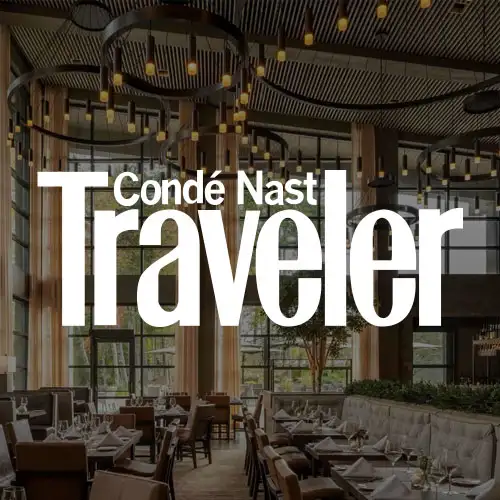 Stylish restaurant interior featuring modern decor, large windows, and elegant lighting, creating a sophisticated dining atmosphere.