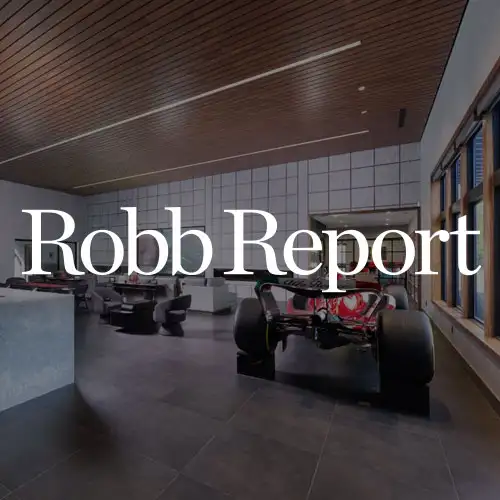 A sleek automotive showroom featuring several race cars and modern architectural design elements.