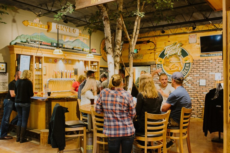 An interior view of Roscoe Beer Co. with people enjoying craft beer at a pub table. 