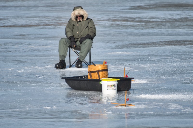 A lone fisherman sits out on the ice fishing in the Catskills.