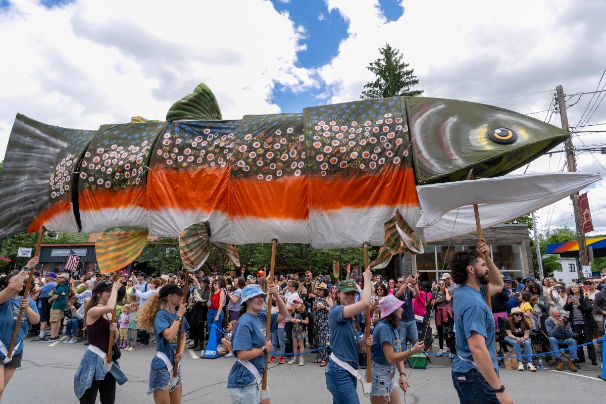 Parade participants carry a large fish puppet is paraded through a crowd during the Trout Parade.