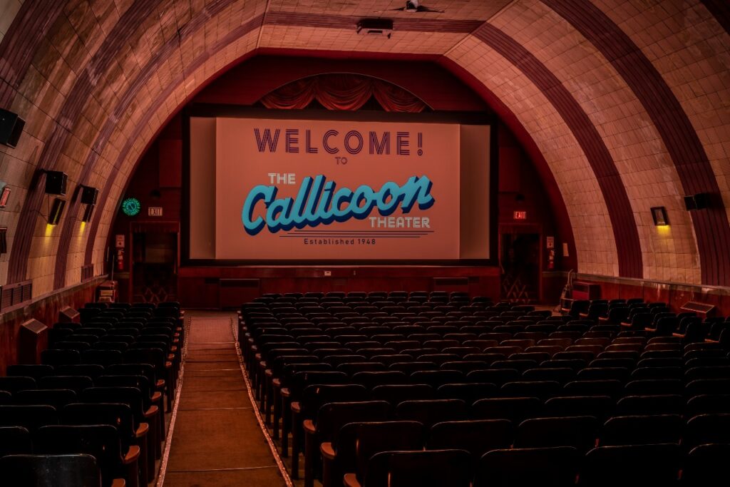 Interior view of empty seats and stage of the Callicoon Theater. 