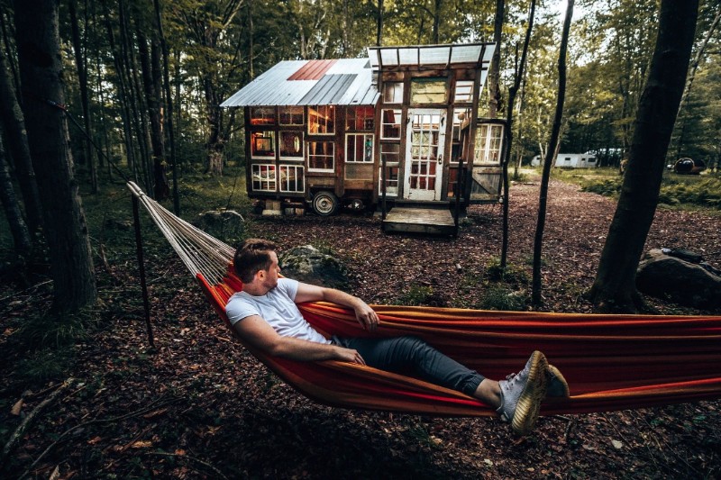 A guest relaxes in a hammock outside the tiny house #4 at The Outlier Inn.